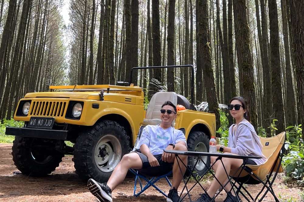 Suasana bersantai di samping Jeep di antara pepohonan hutan pinus