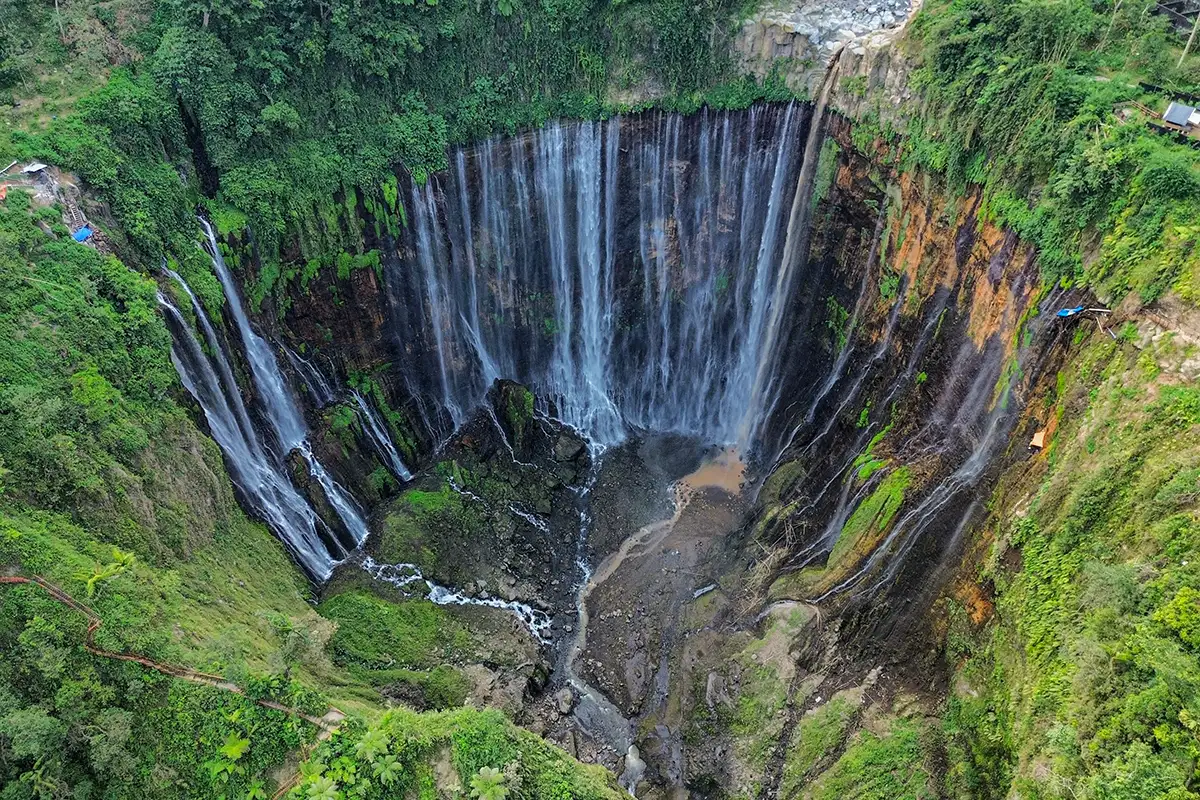 Panorama bertingkat Air Terjun Tumpak Sewu di tengah tebing hijau
